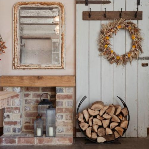 Matte black curved log holder full of logs in autumn styled rustic cottage home.