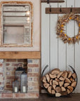 Matte black curved log holder full of logs in autumn styled rustic cottage home.