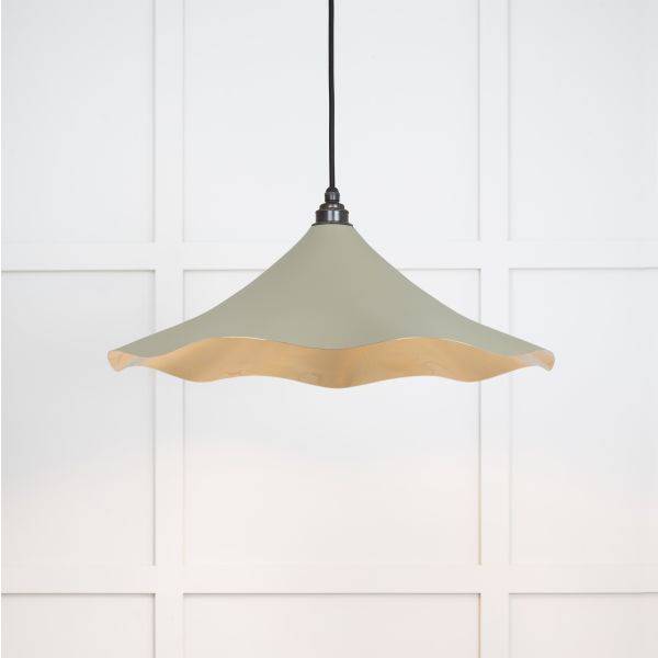 Shade of floral brass and green pendant light, switched on.