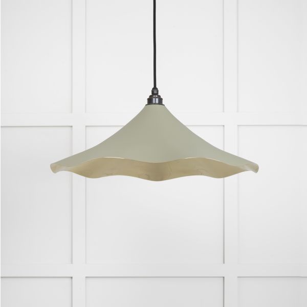 Shade of floral brass and green pendant light, switched off.