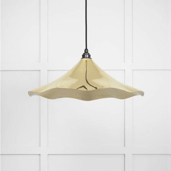 Shade of floral shaped smooth brass pendant light, switched off.