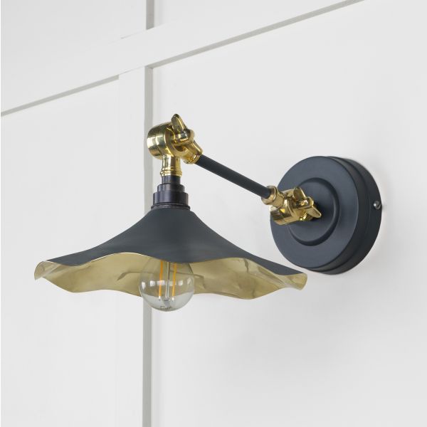 Black and brass floral wall light, attached to wall and switched off.