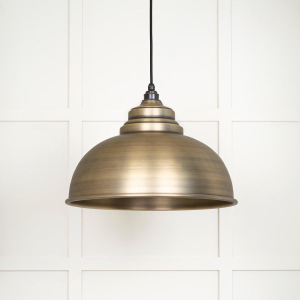 Close up of shade on aged brass pendant light, switched off.