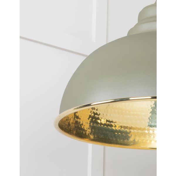 Close up of shade on hammered brass pendant light in green.