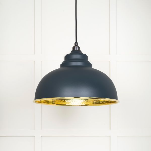 Shade on brass and black pendant light, switched on.