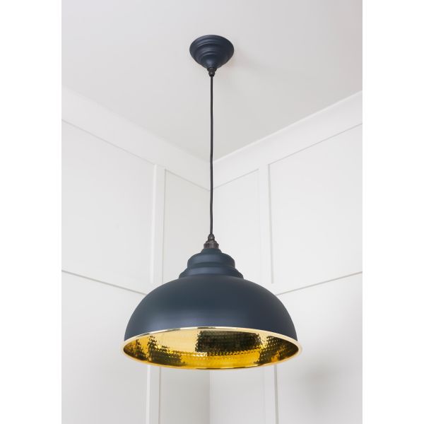 Brass and black pendant light, switched off.