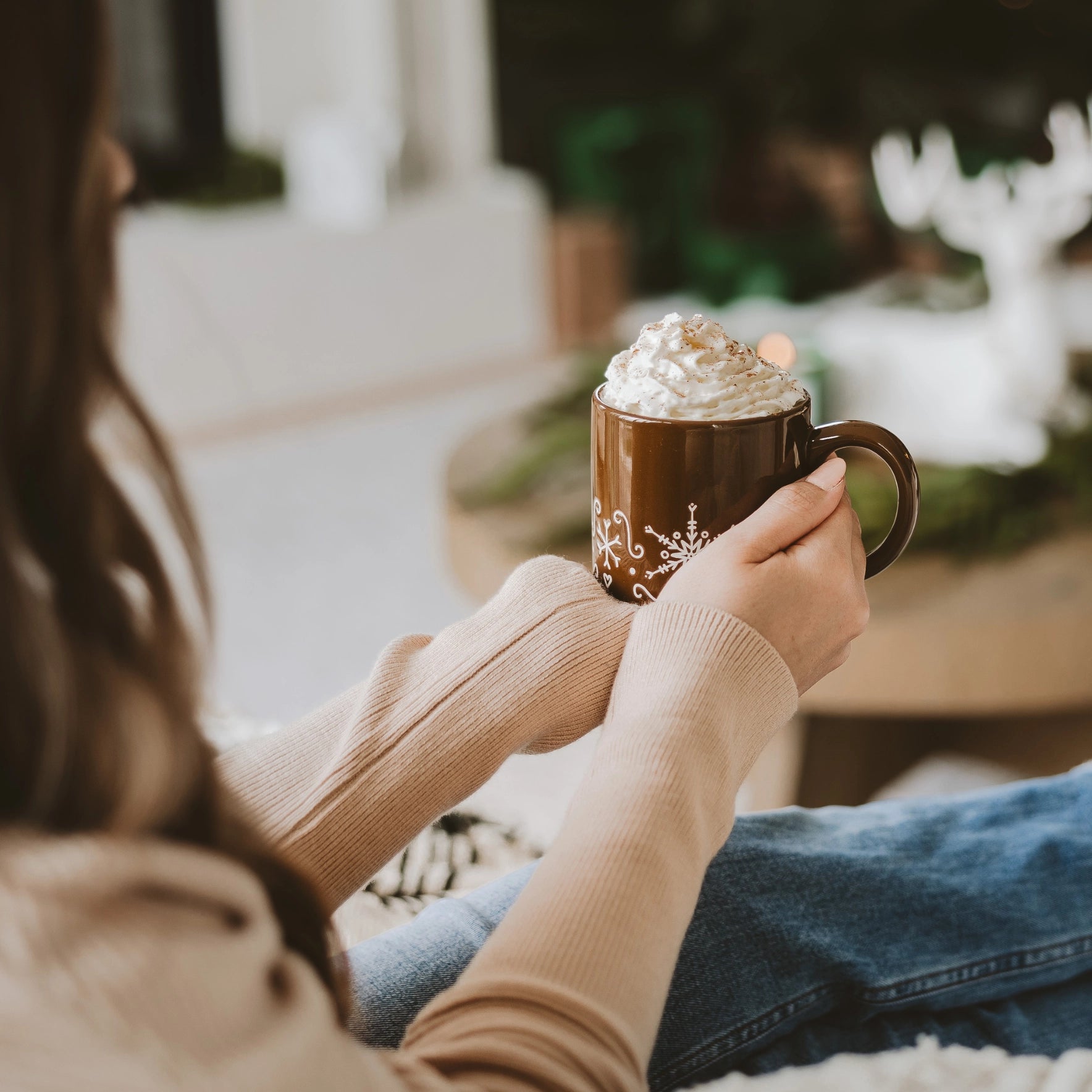 Gingerbread stoneware mug filled with whipped cream, and held with two hands.