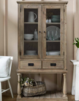 Glass Display Cabinet filled with crockery and a basket of flowers.