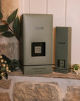 Green florist Sences reed diffuser with presentation boxes on stone windowsill.