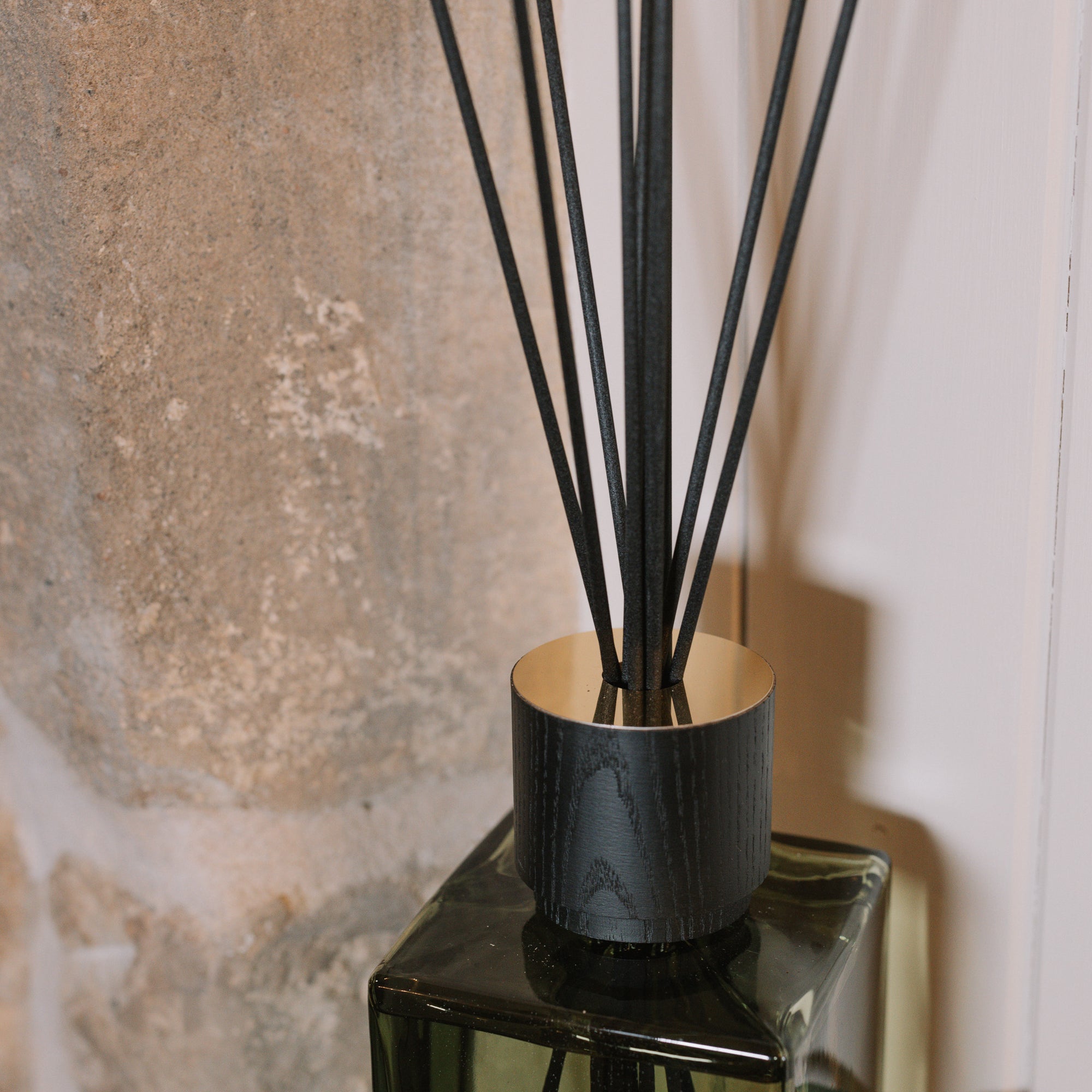 detail shot on Green florist Sences reed diffuser by stone wall.