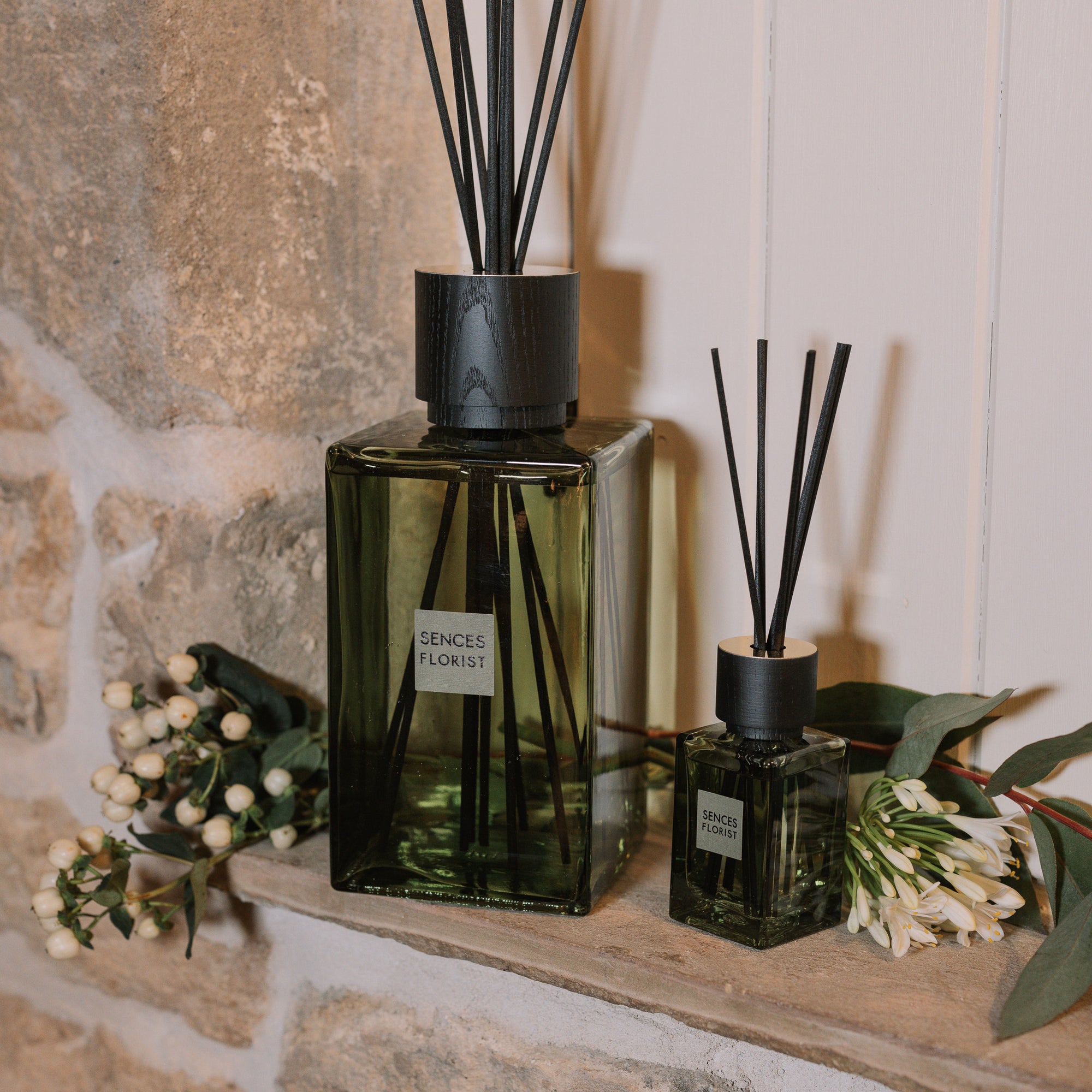 Green florist Sences reed diffuser in XL and mini on stone windowsill.