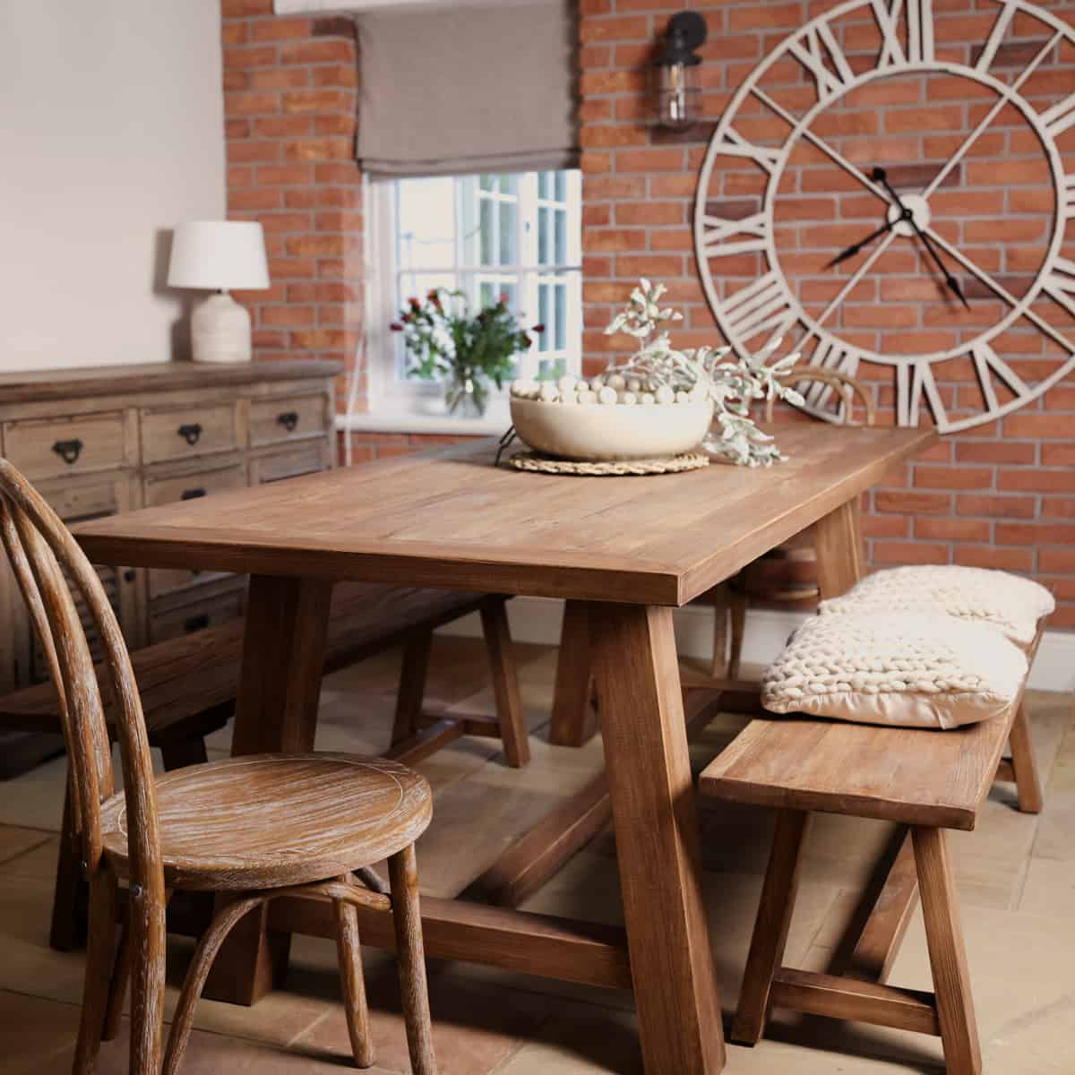 Oak dining set with table and bench, styled with bobble bowl and large clock in background.