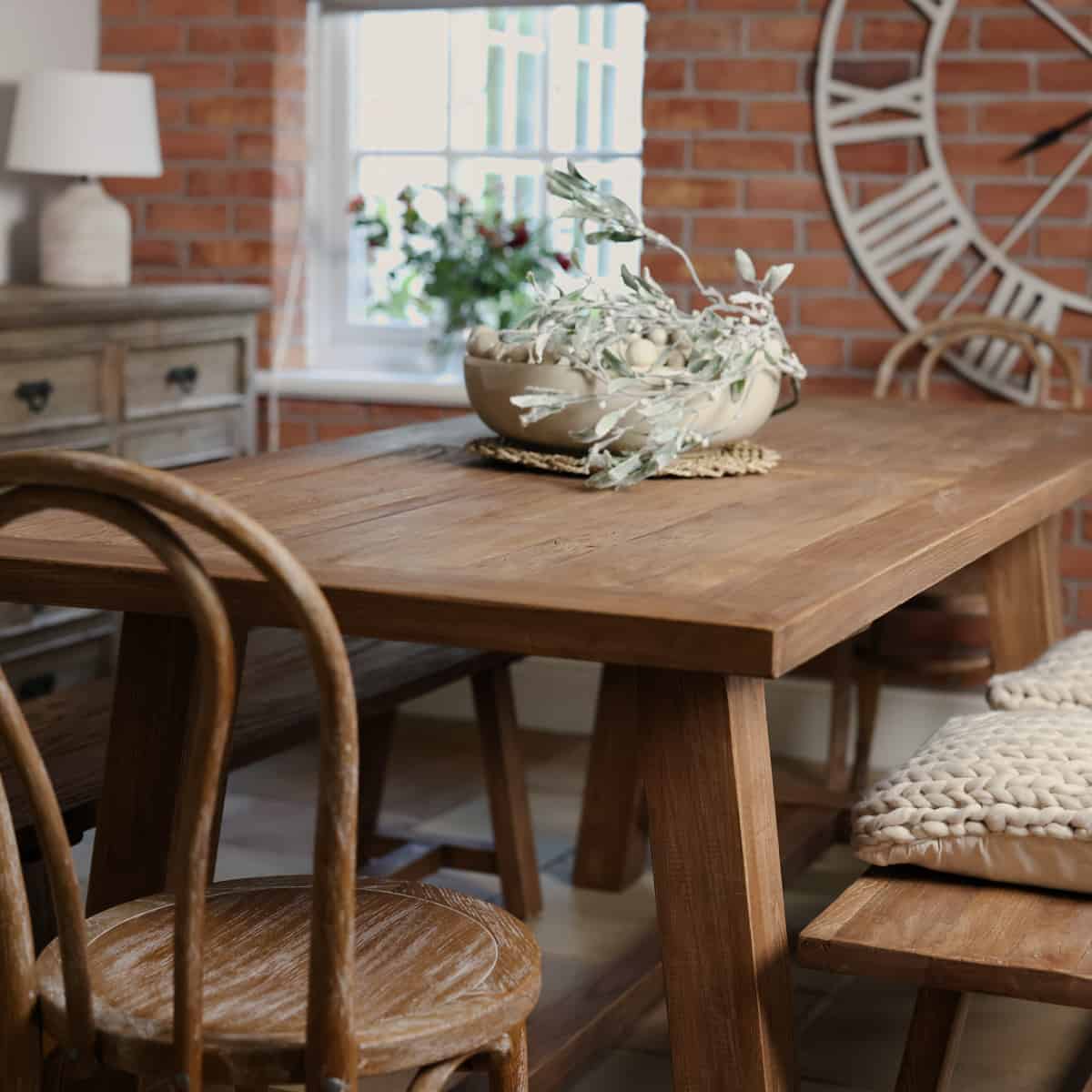 Elm dining table close up styled with bobble bowl and greenery.