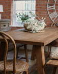 Elm dining table close up styled with bobble bowl and greenery.