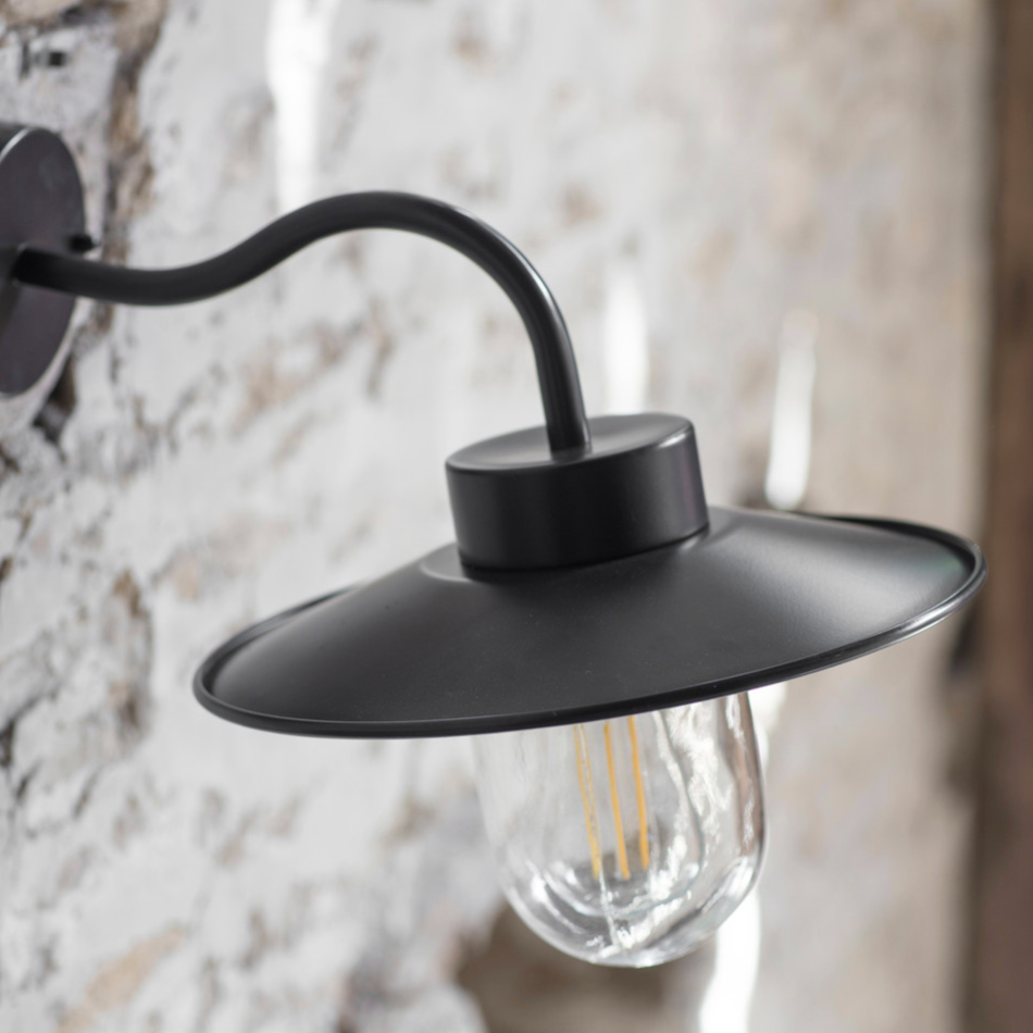 Black swan neck outdoor wall light on stone wall.