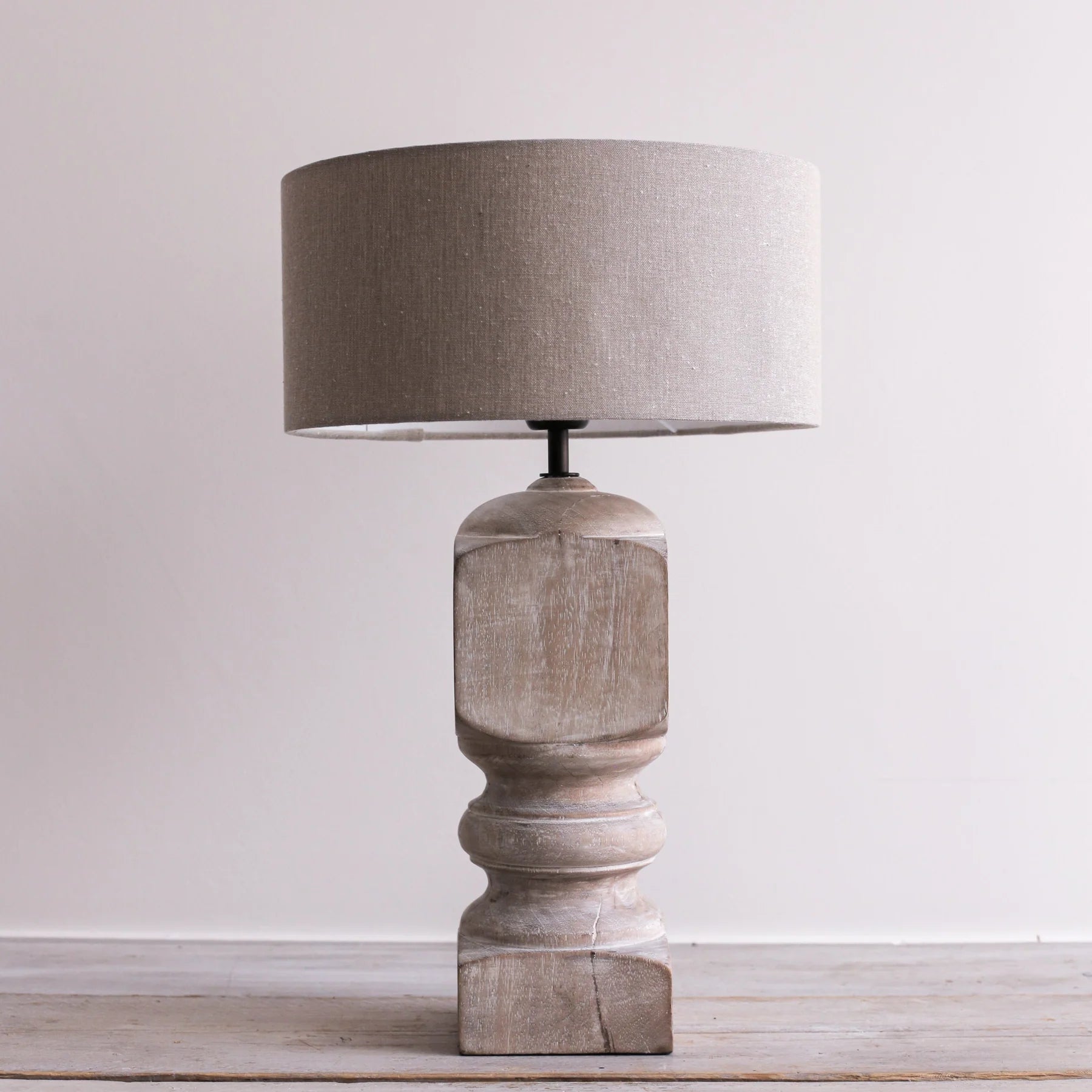 A large white washed mango wood table lamp with a natural cotton shade.
