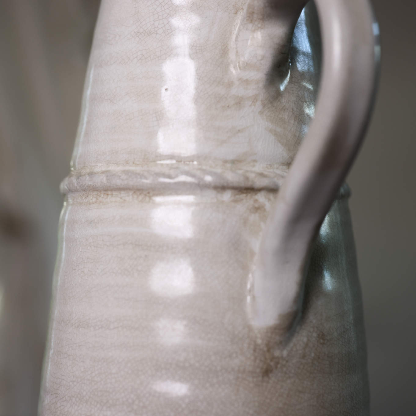 Close up of handle on cream vintage jug texture.