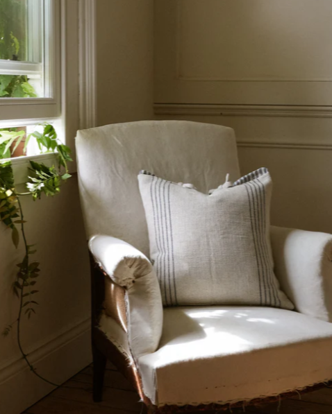 Cream and blue striped cushion on cream armchair.