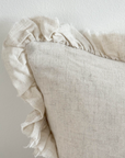 Close up of ruffled edge on sand coloured bolster cushion.