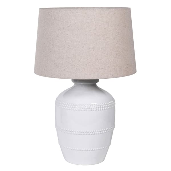 White ceramic table lamp with beaded detailing and linen lampshade.