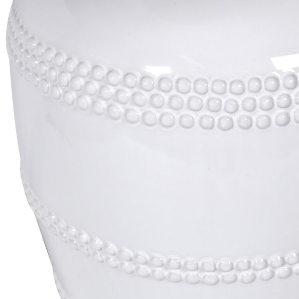 Close up of white ceramic table lamp with beaded detailing.