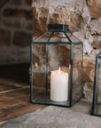 Set of two black and Glass Lanterns on stone hearth.