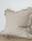 Light brown striped cushion with ruffled frayed edge.