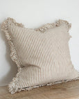 Light brown striped cushion with ruffled frayed edge.