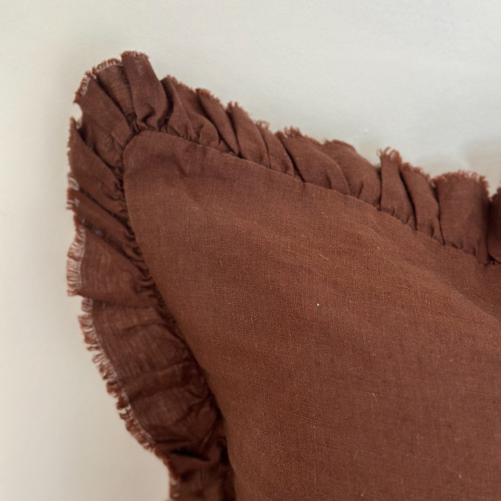 Close up of ruffled edge on chocolate linen cushion.