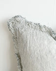 Close up of frayed edge on linen pinstripe cushion.