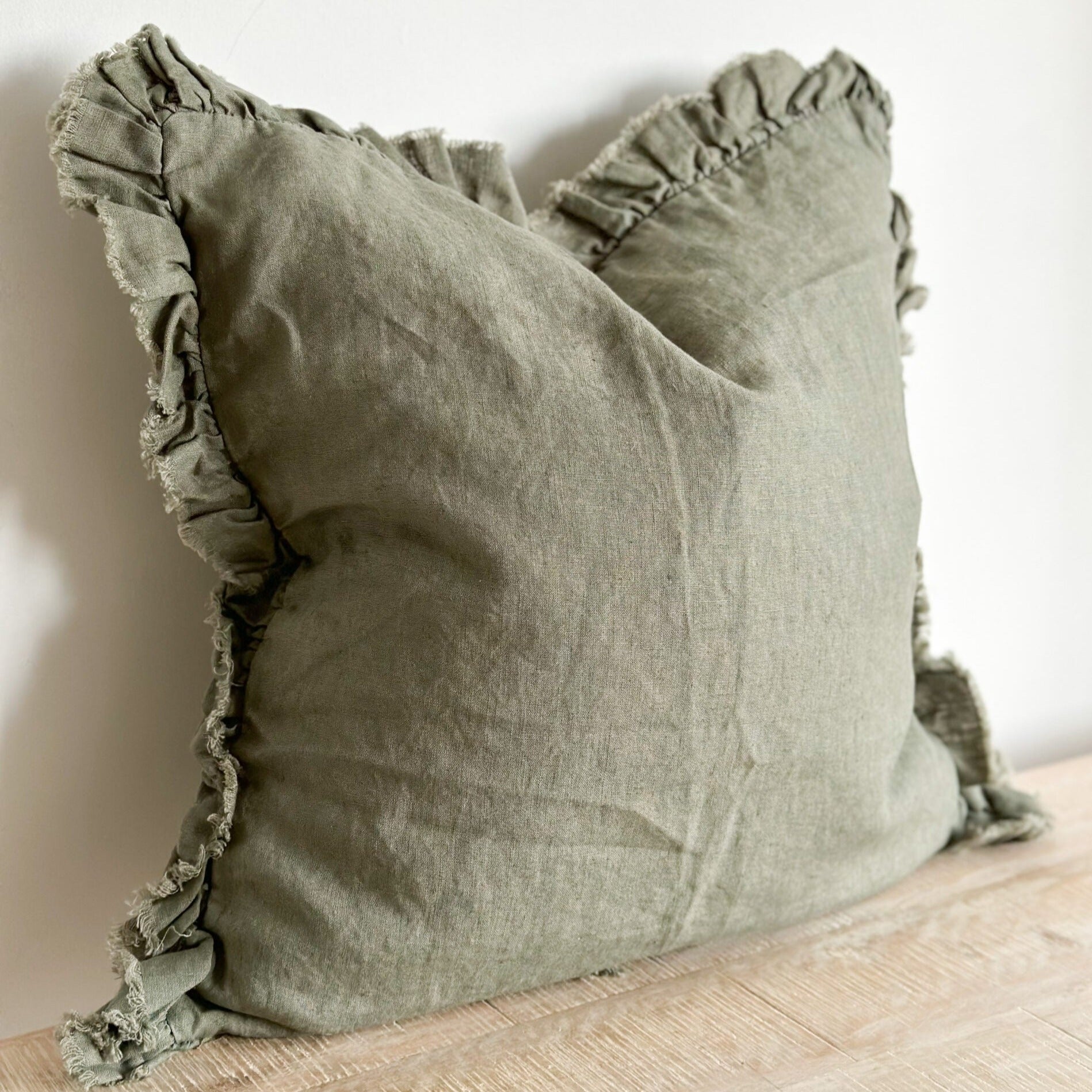 Green cushion will ruffled frayed edge.