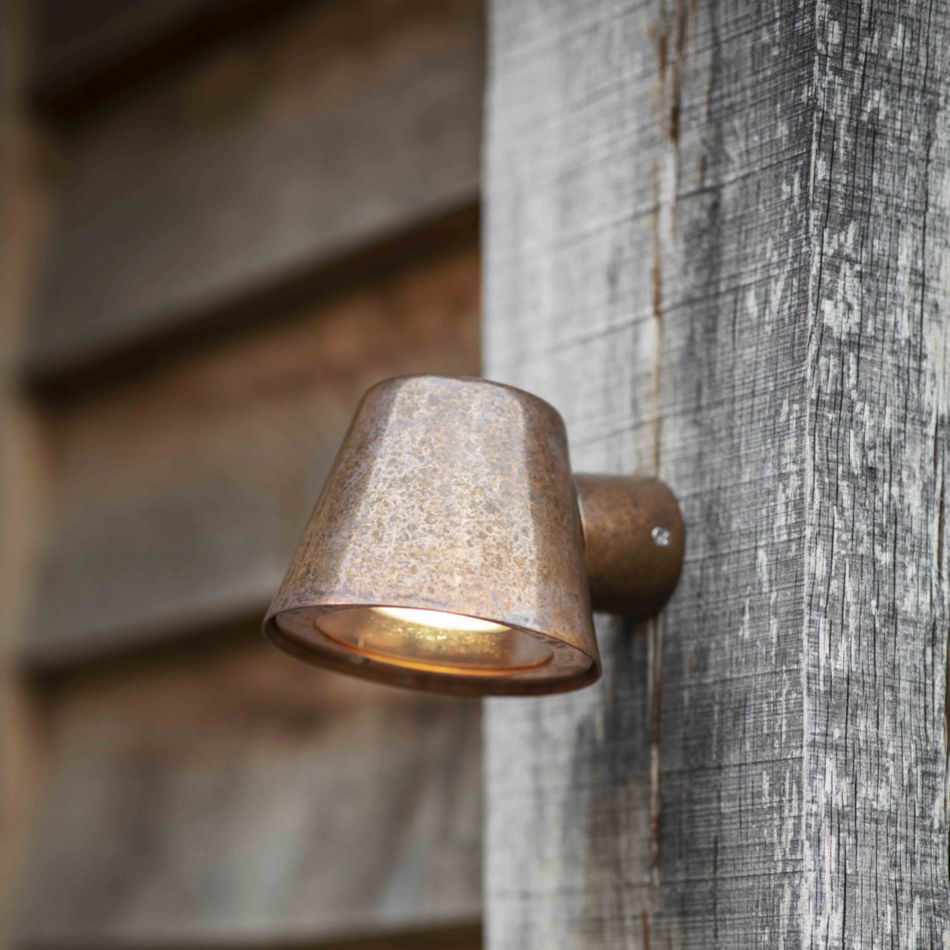 Rustic copper mast light on wooden post.