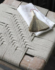 Lulworth Rustic Wooden Stool with rope seat and white napkin with straw brush on top.