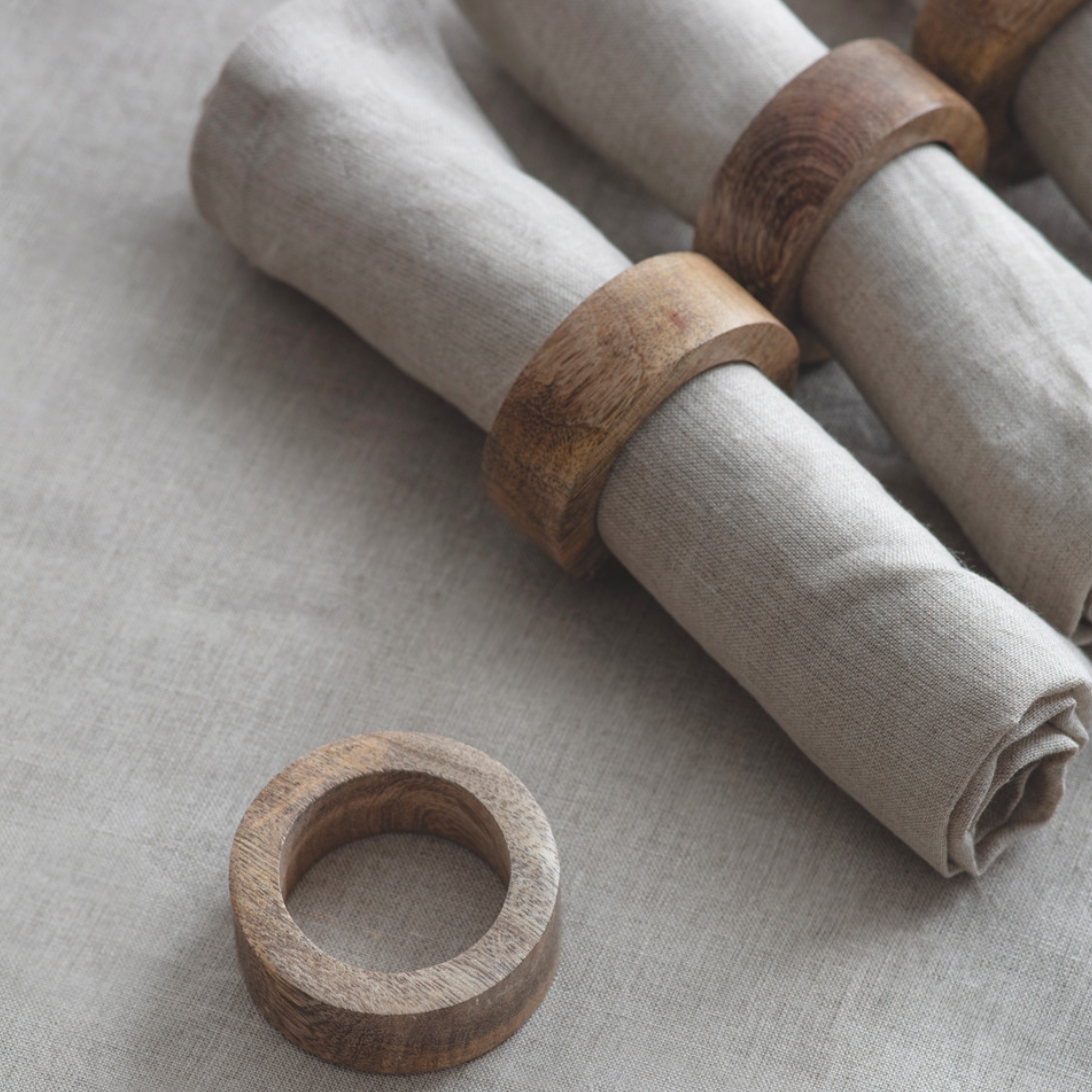 Mango wood napkin rings around neutral napkins.