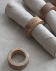 Mango wood napkin rings around neutral napkins.