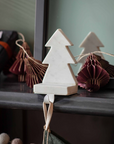 White marble Christmas tree stocking holder on a mantel with decorations.