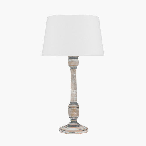 Small wooden grey wash table lamp with a white shade on.