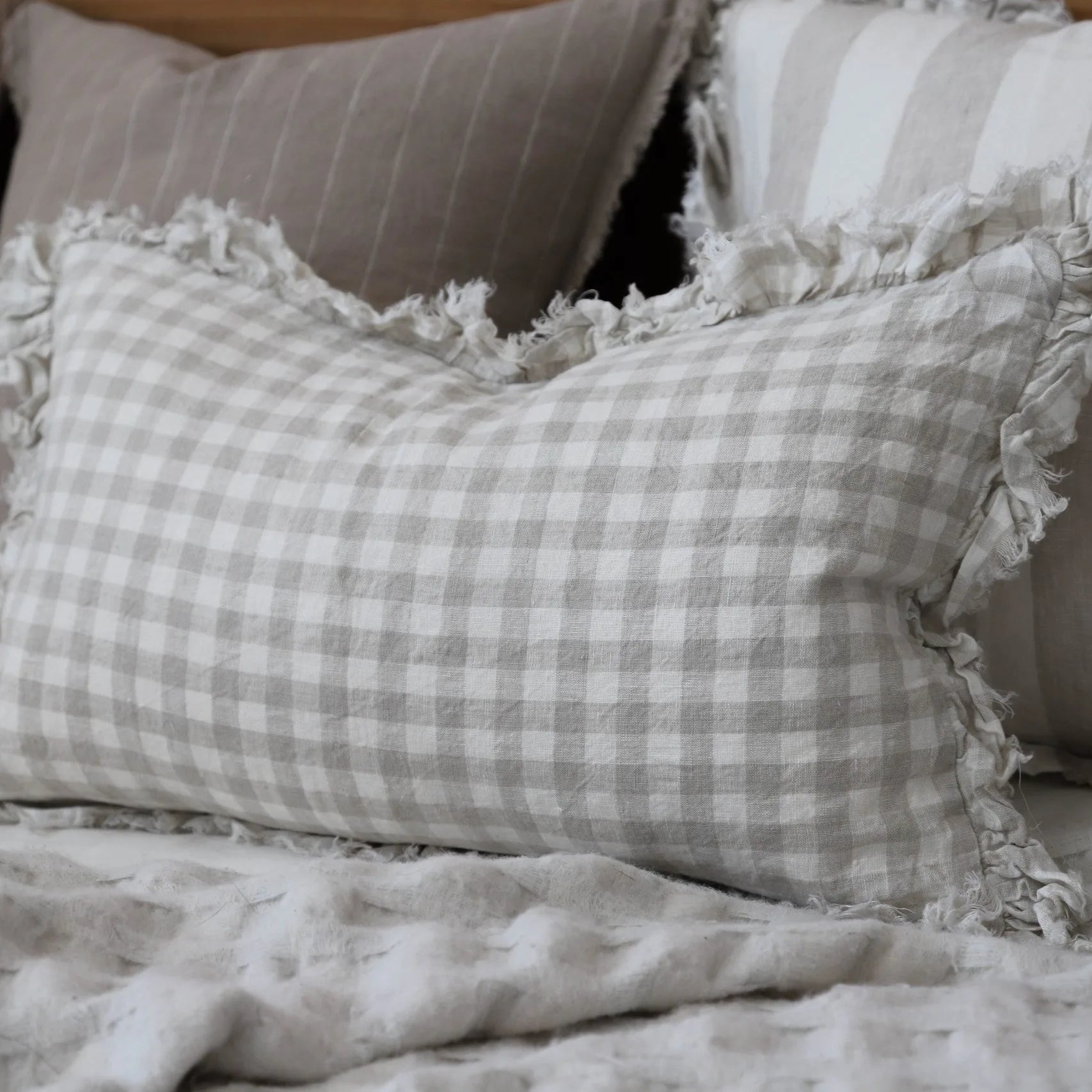 Rectangular shaped Natural Gingham Cushion on nutral bed.