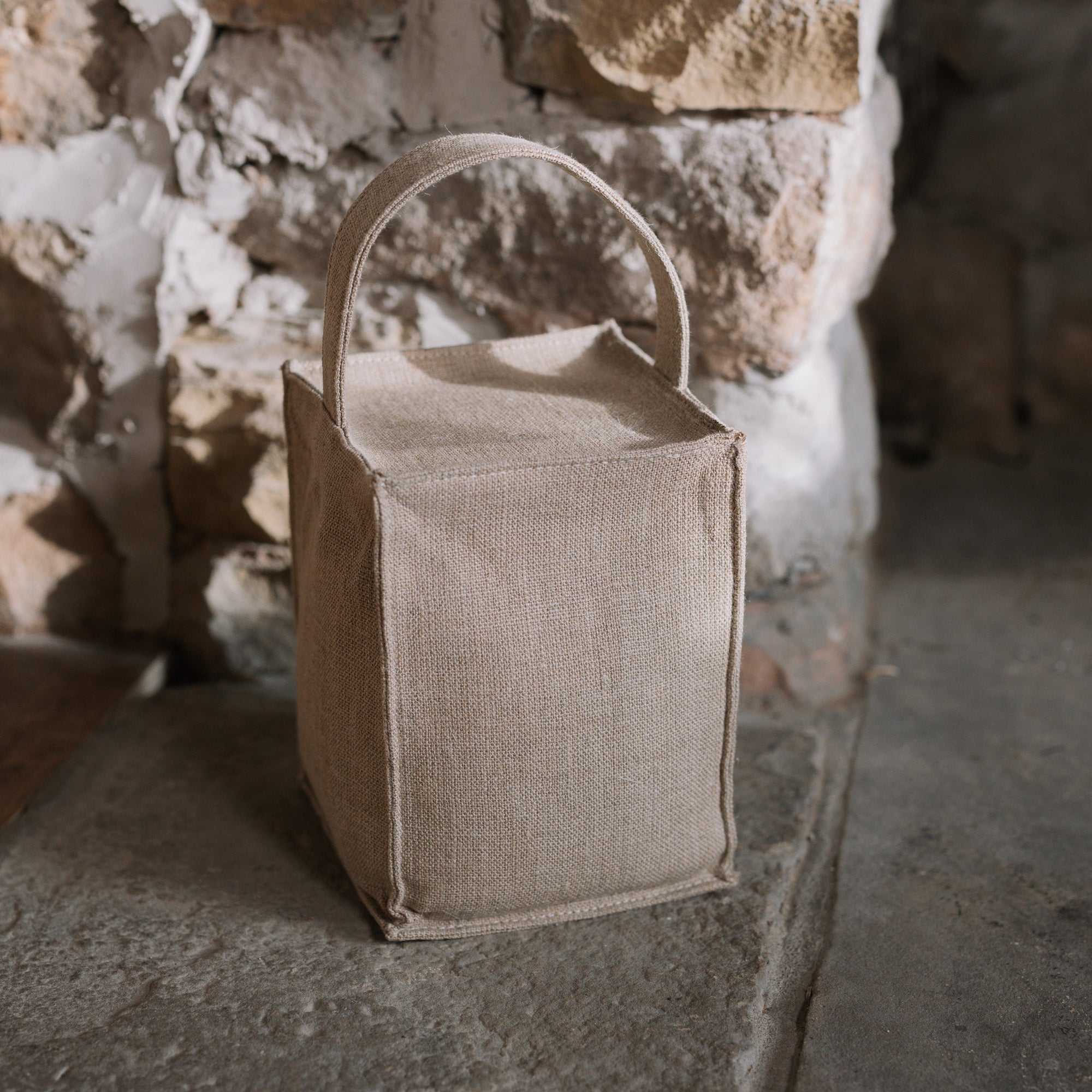 Natural linen doorstop with handle on stone hearth.