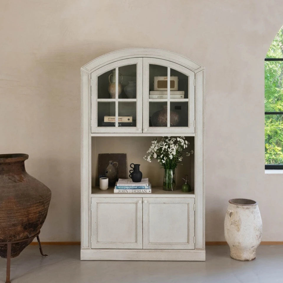 arched cabinet in neutral room with decor.