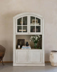 arched cabinet in neutral room with decor.