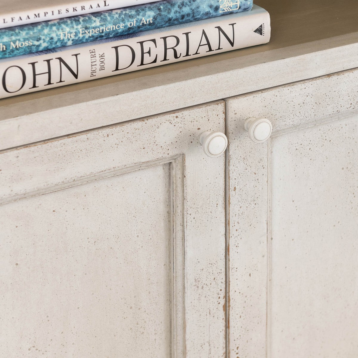 detail shot of rustic white finish on arched cabinet.