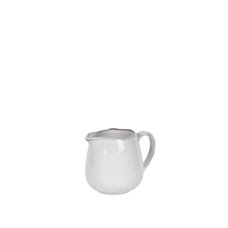 Off white speckle glaze milk jug from spout view.