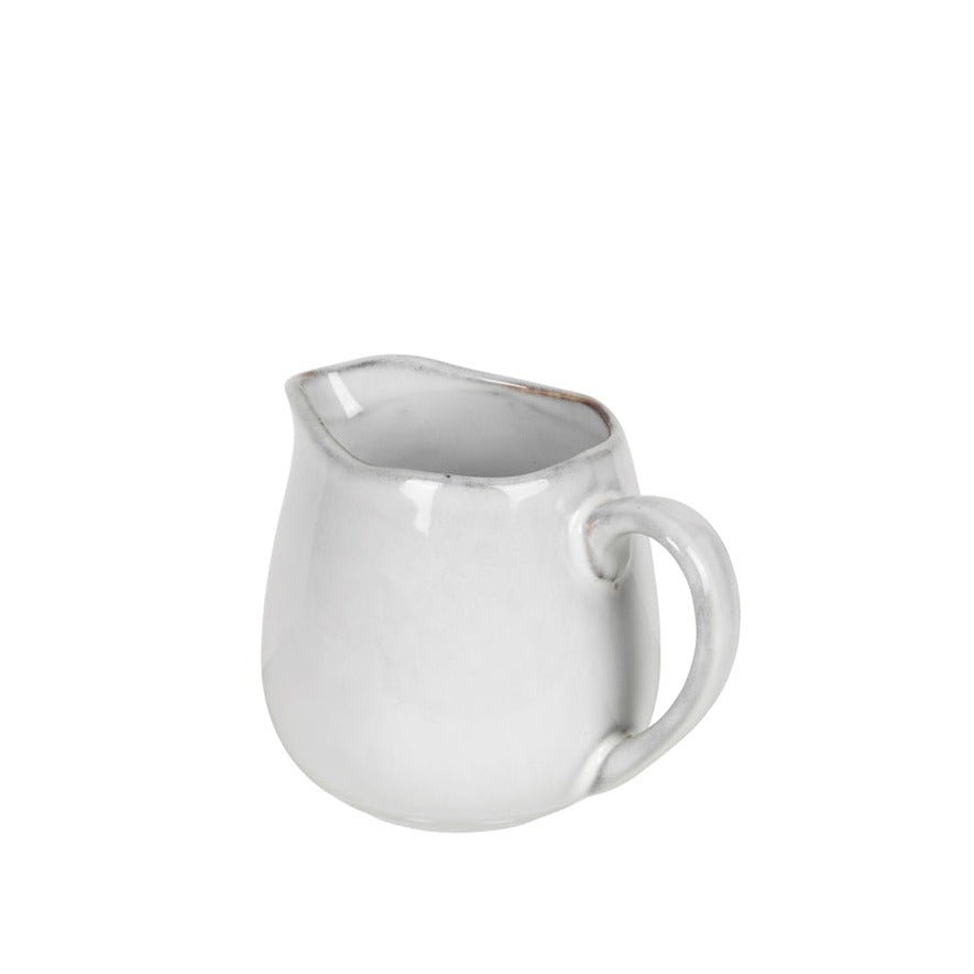 Off white speckle glazed jug from handle view.