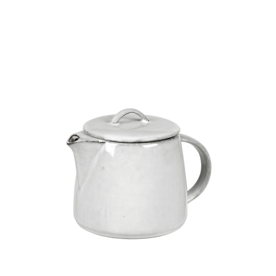 Off white speckle glazed tea pot from spout view.