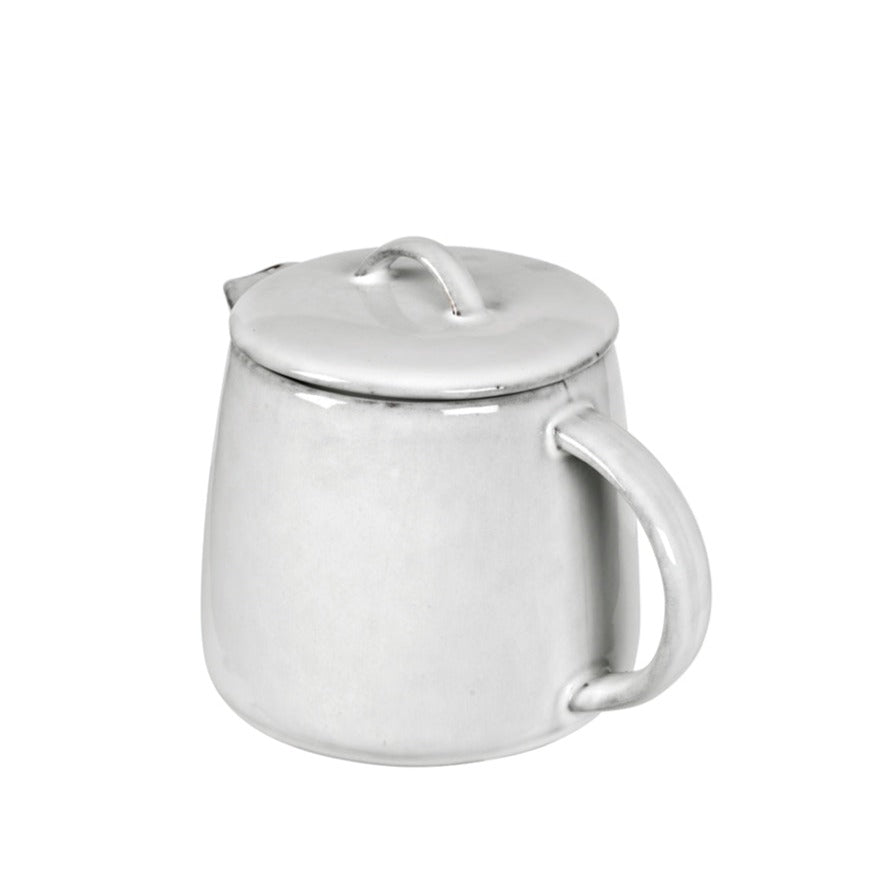 Off white speckle glazed tea pot from handle view.
