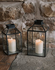 Set of two black and Glass Lanterns on stone hearth.