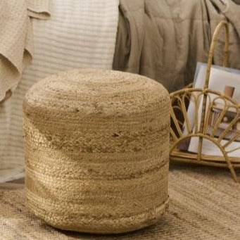 Round jute pouf in neutral room.