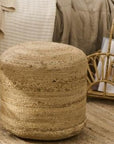 Round jute pouf in neutral room.