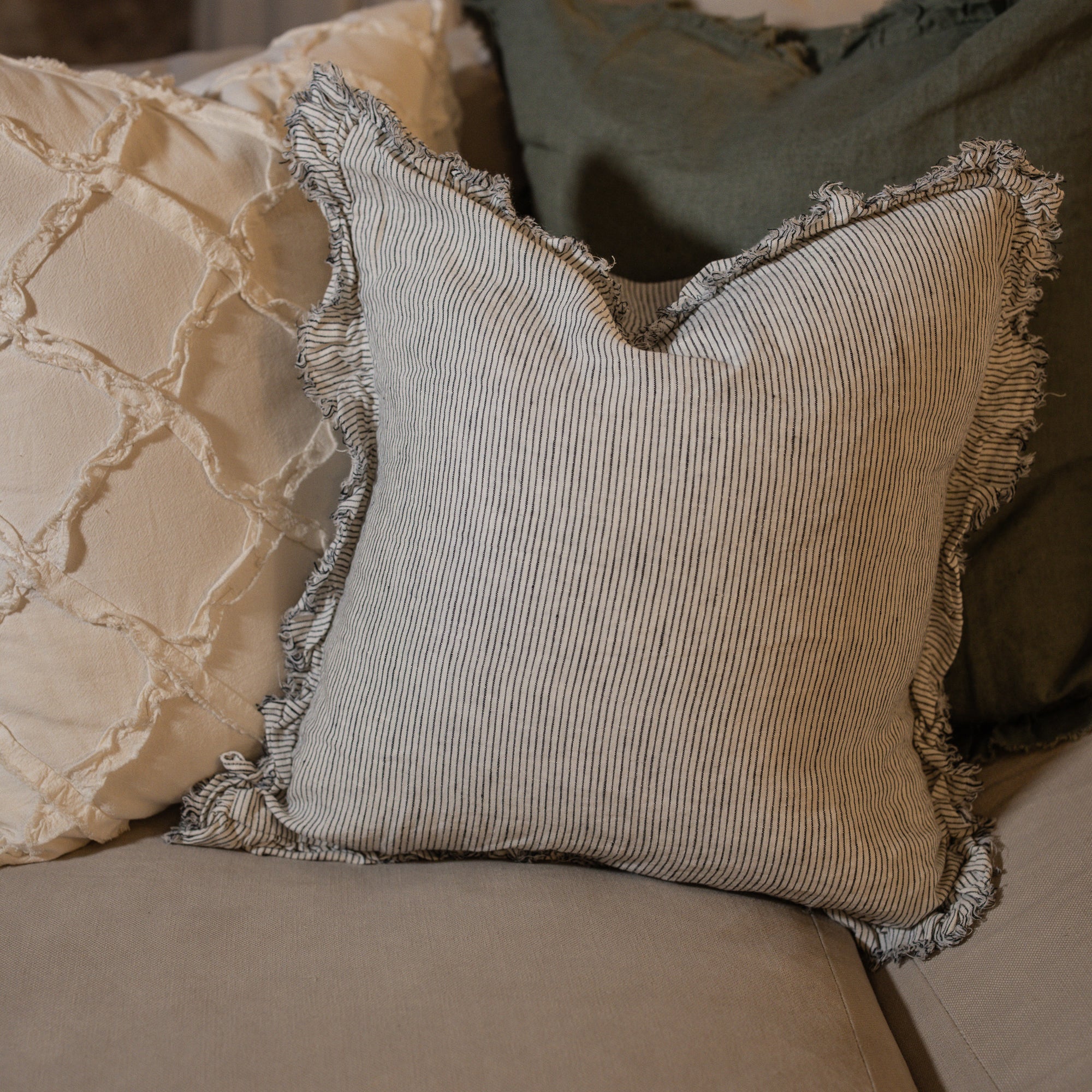 Pinstripe black and white linen cushion with frilled edge.